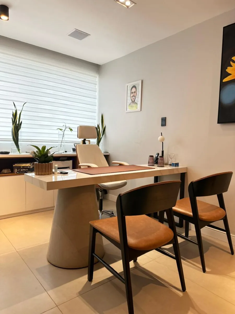 Mesa de consulta do Dr. Jayme Assunção com cadeiras para o paciente e acompanhante